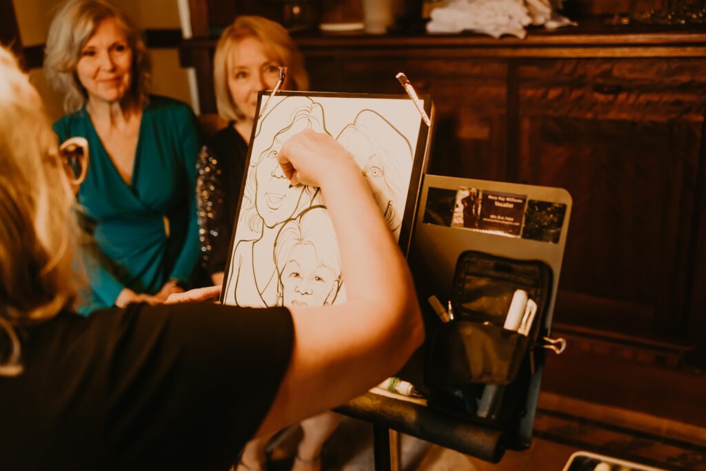 A caricature artist drawing a sketch of three ladies