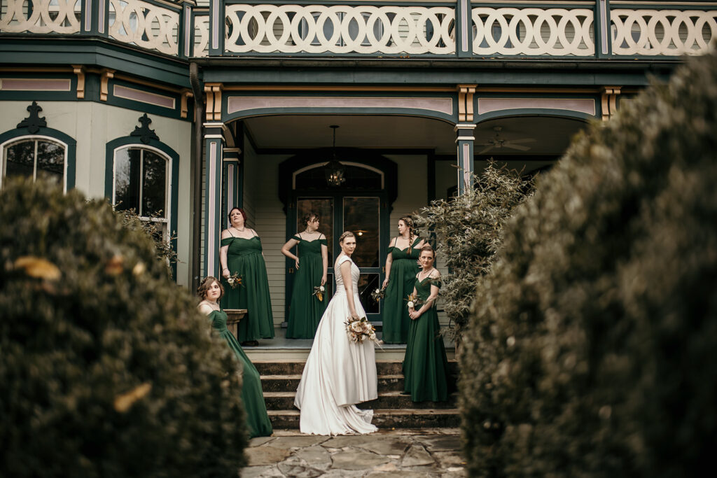 bride with her wedding attendants in front of magnolia house in hot springs, north carolina.