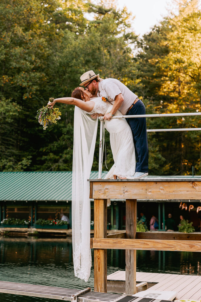couple on their wedding day kissing on a swim platform