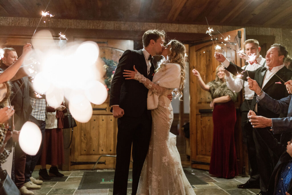 bride and groom kissing during their sparkler exit