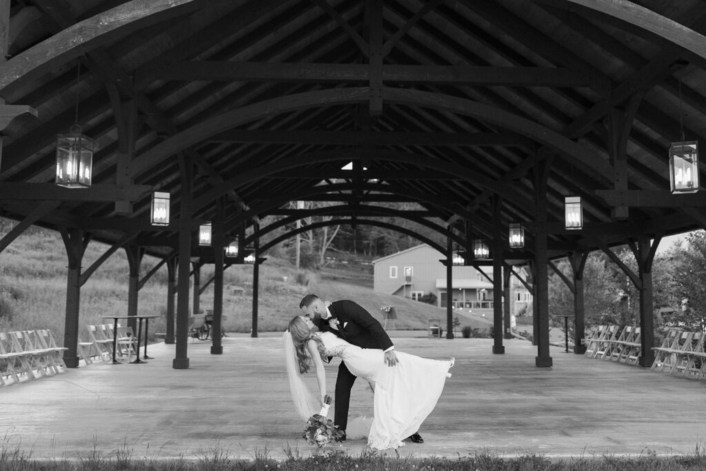 bride and groom kissing in an empty pavilion