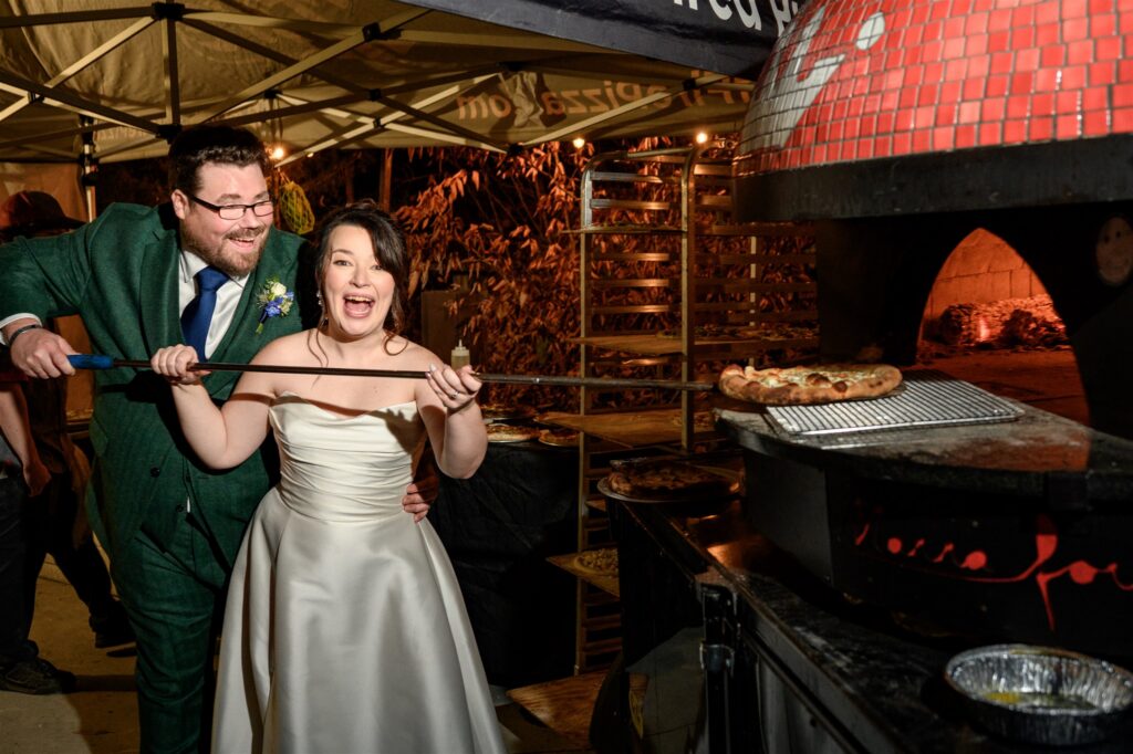couple serving pizza at their wedding